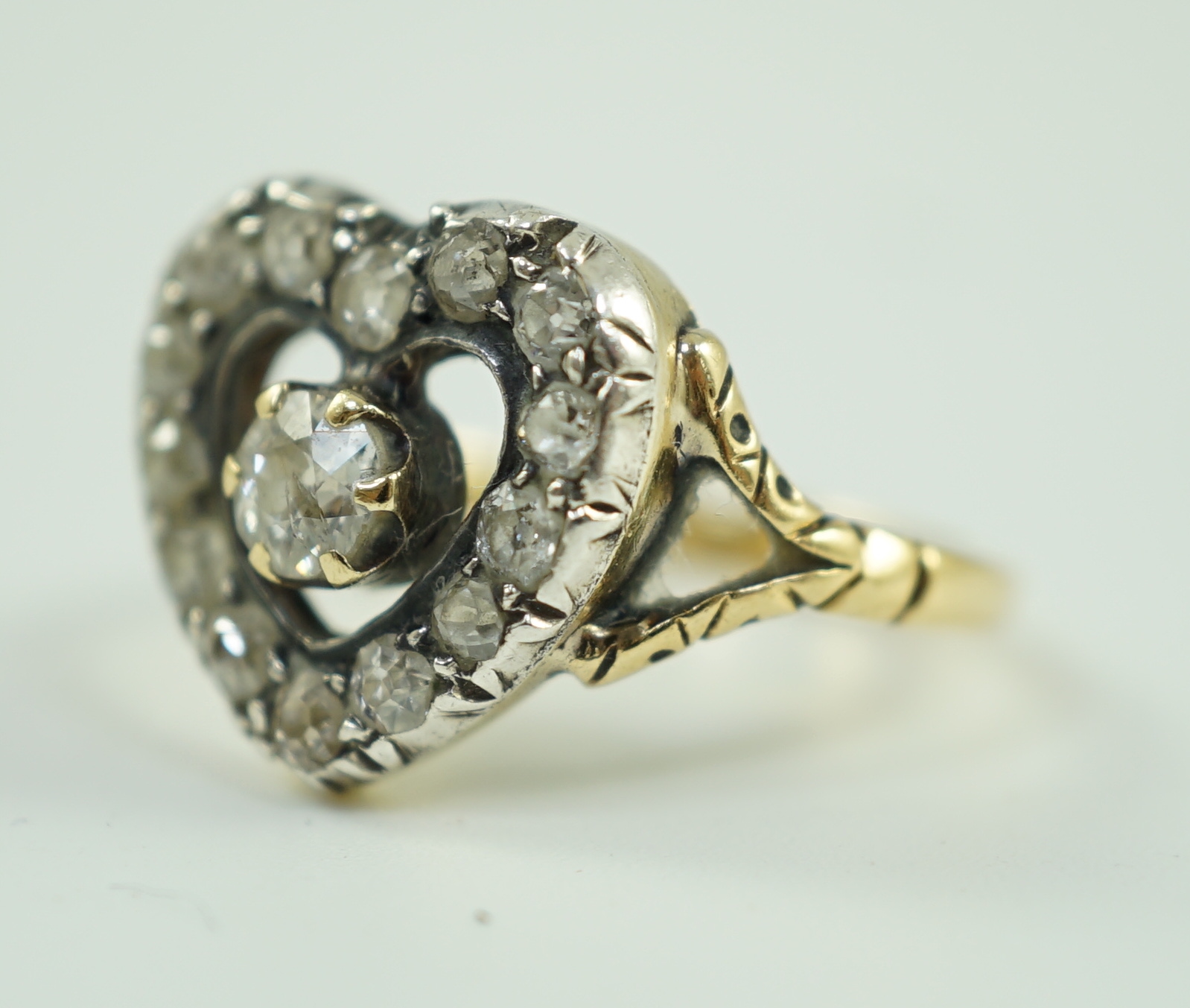 An antique gold and diamond set heart shaped open work cluster ring